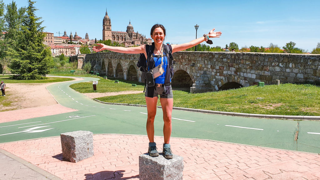 A happy women in front of the bridge leading into Salamanca, Via de la Plata Stage