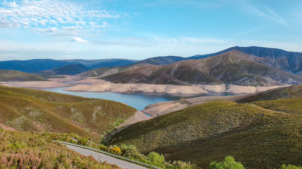 View from above of a river winding through a valley, surrounded by hills and mountains