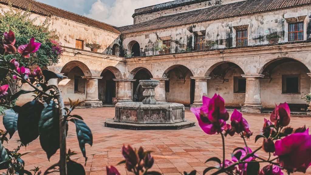 Courtyard at Convento Las Capuchinas in Antigua Guatemala with a fountain at the center and arched cloisters