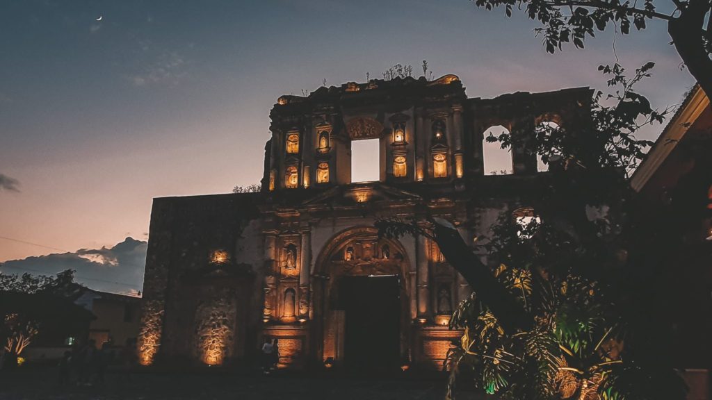 Ruined facade of a church in Antigua Guatemala, illuminated in the late evening