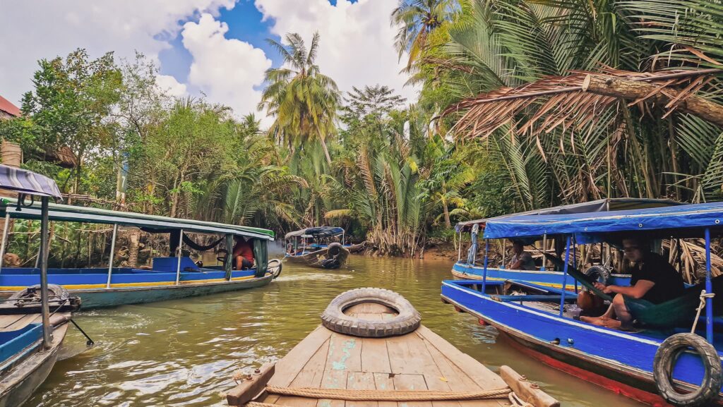 Vietnam boat trip Traditional Vietnamese boats on a river surrounded by palm trees
