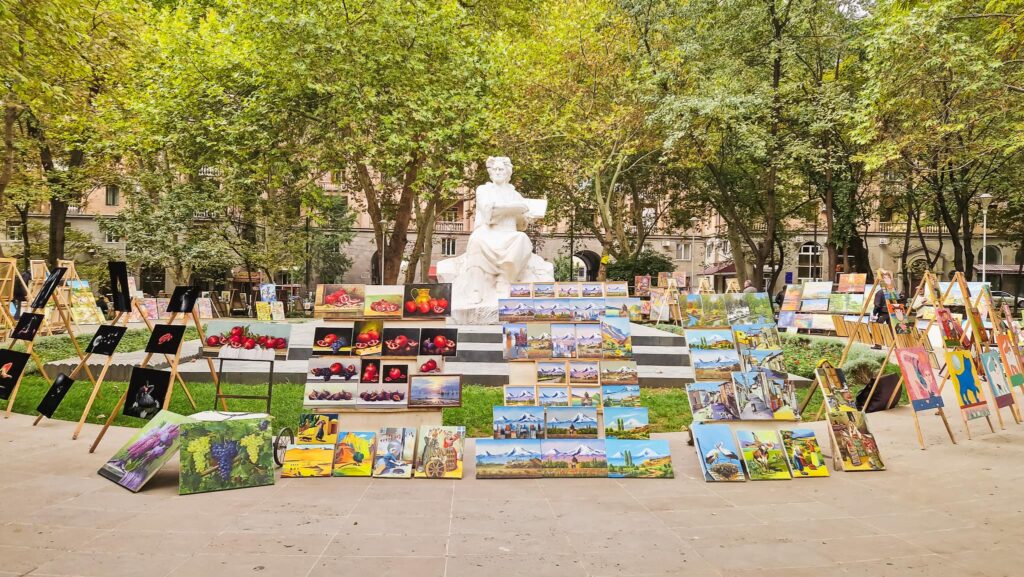 Paintings in a park with a statue at the center