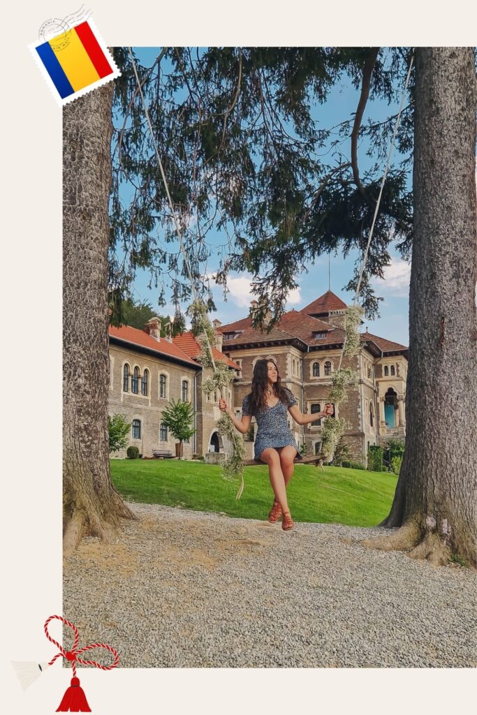 RoxInRomania Young woman on a swing between two large trees in a sunny courtyard with a historic brick building in the background, blue sky above.