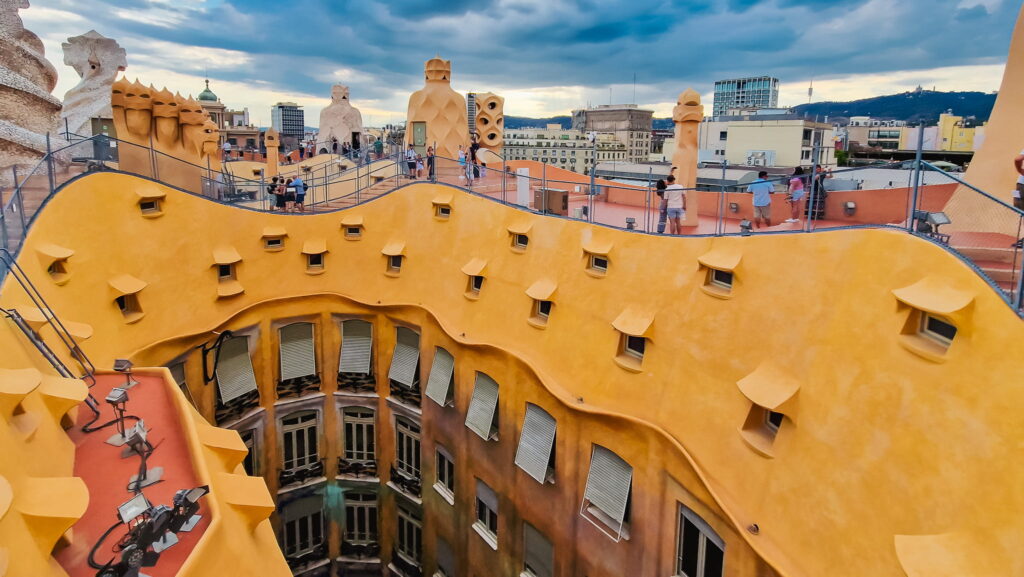 La Pedrera rooftop view La Pedrera in Barcelona, yellow inner courtyard and rooftop with chimneys