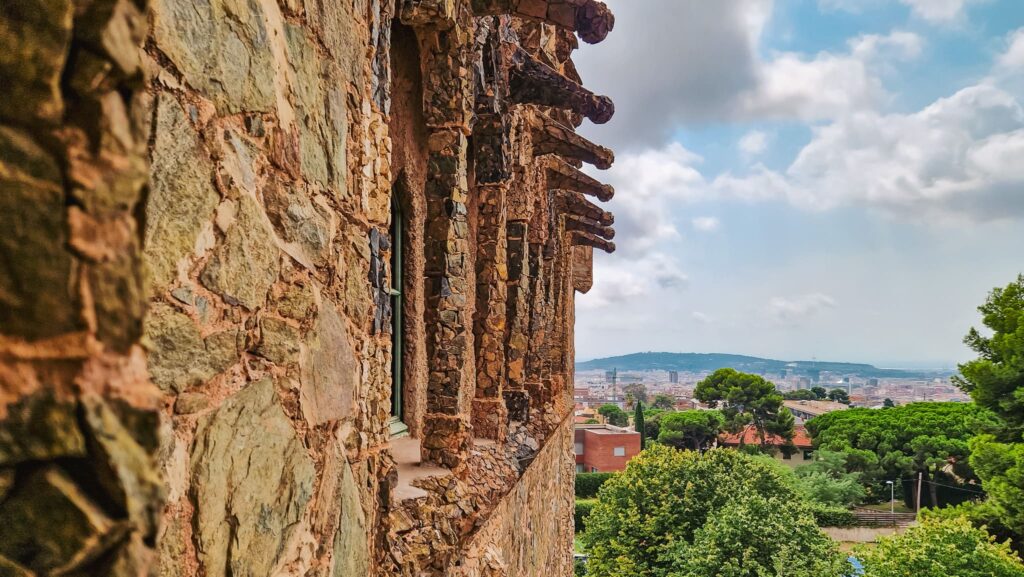 Torre Bellesguard, view Stone building external wall and view of Barcelona in the distance