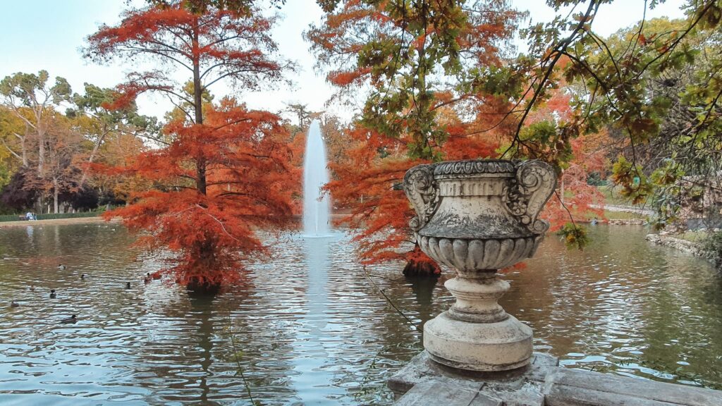 Fall in El Retiro Lake with fountain surrounded by trees with orange leaves, El Retiro