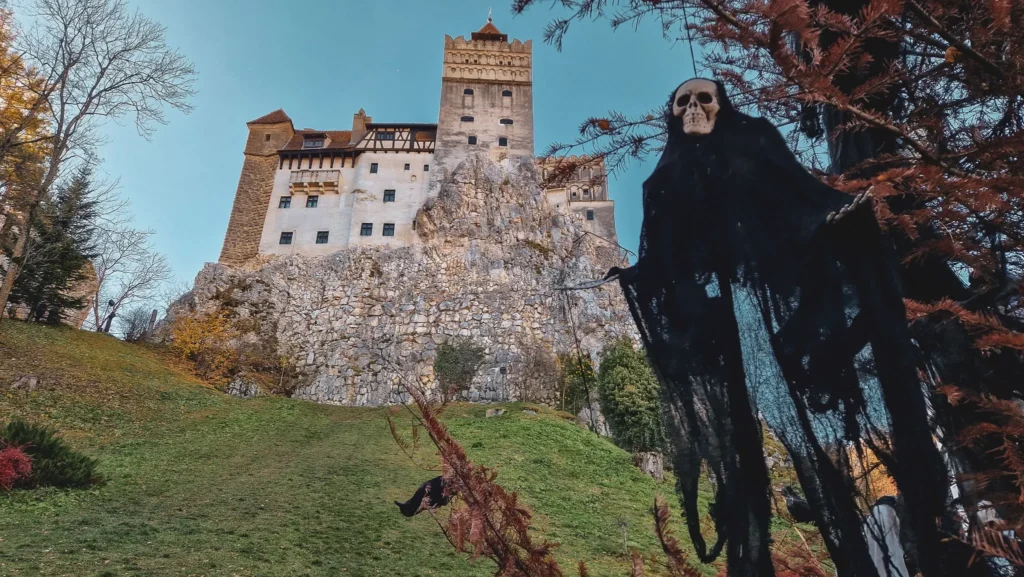 Bran castle at Halloween Bran Castle in the background with a skeleton hanging from a tree in the foreground