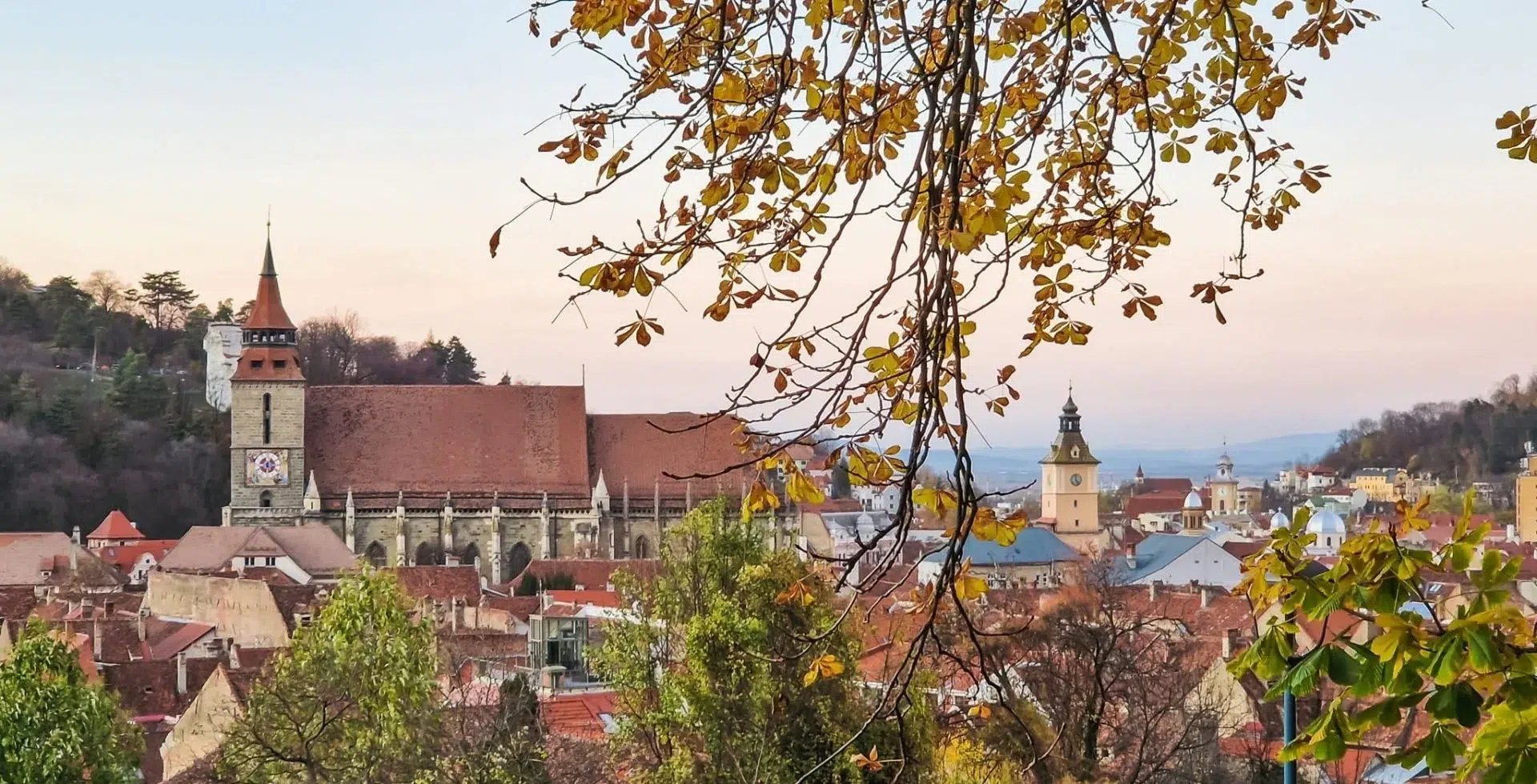 View of Brasov in Autumn - The Black Church framed by autumn leaves